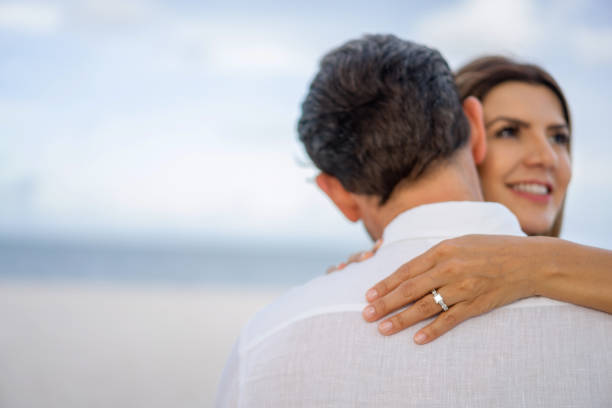 istock Happy couple hugging at the beach after getting engaged 1329716321