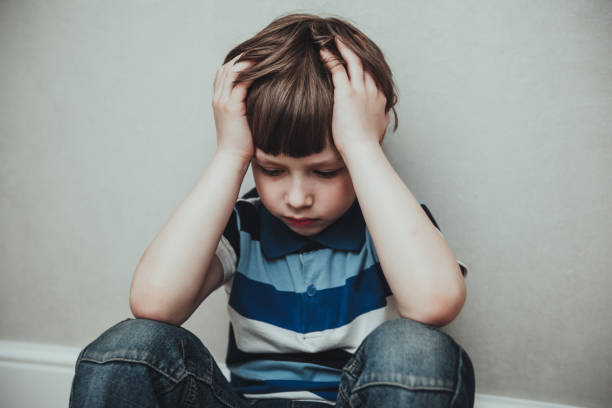 regret sad little boy sitting alone loneliness,stressed depressed child crying having depression, anxiety, trouble of mental health, lonely kid boy with hands on head, hikikomori syndrome disease - little boys child sadness depression imagens e fotografias de stock