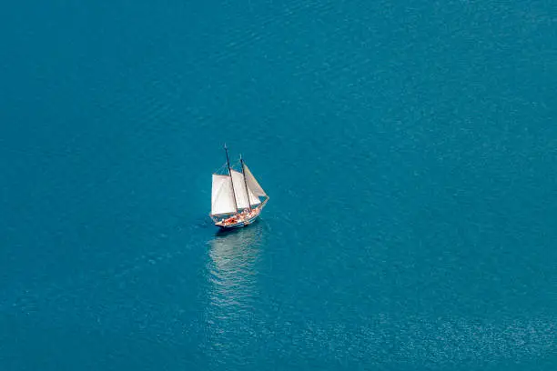 Sailing ship (two-master) makes its way through the calm seas.