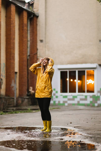 young pretty smiling woman portrait in raincoat with hood. overcast weather