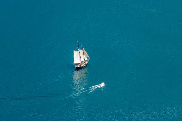 Sailing ship (two-master) makes its way through the calm seas.