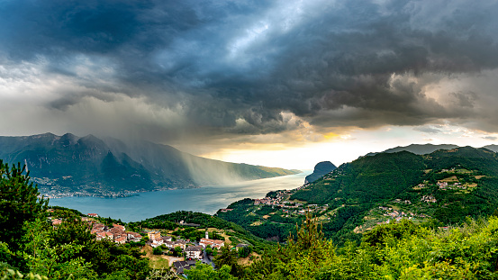 A dark wall of rain crosses Lake Garda and meets the mountains