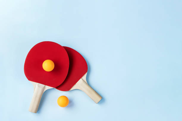 istock Two red ping pong paddles on light blue background 1329727237