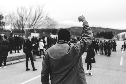 Man protests in the street with raised fist