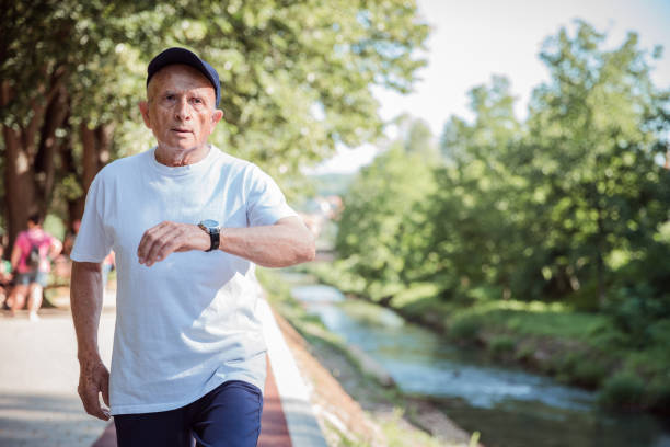 istock Senior man checking the time as he runs in the park 1329730167
