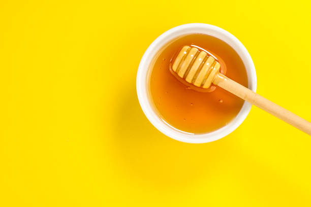 istock honey dipper on yellow background in top view 1329730722