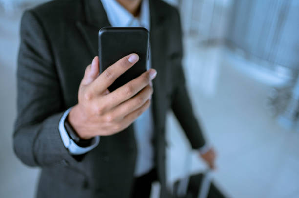 istock Asian  businessman using mobile phone at airport. 1329732277