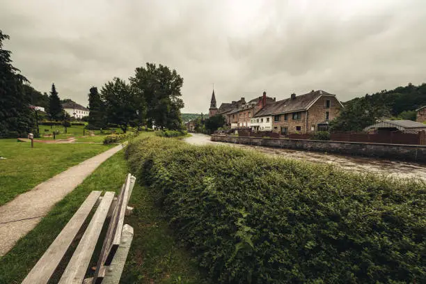 River Ourthe meanders through the center of Houffalize in the Belgian Ardennes on a cloudy day after heavy rains and floods