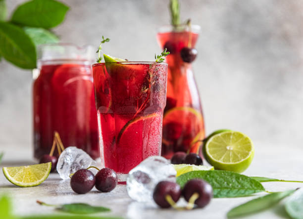 istock Cocktail or lemonade with cherries and lime, grey stone background. Mocktail. Cold summer drink. 1329738643