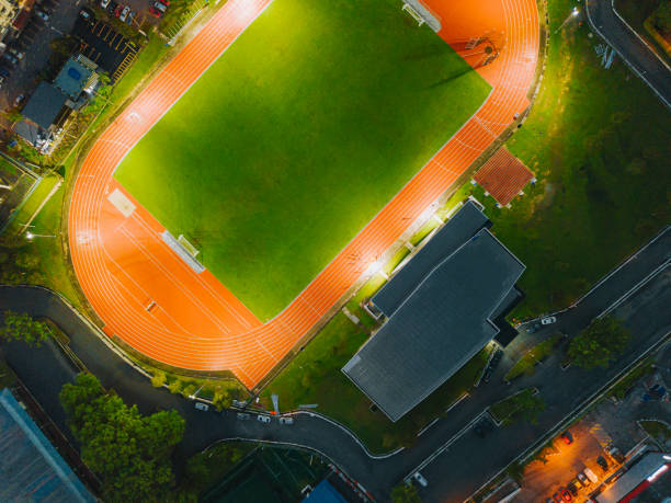 punto de vista del dron directamente sobre el estadio de atletismo por la noche - sports track track and field stadium sport night fotografías e imágenes de stock