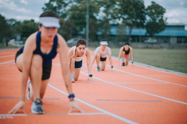 istock asian chinese  female athletes lining up  starting line aerodynamic shape getting ready to run at track rainy late evening in stadium cloudy day 1329740989