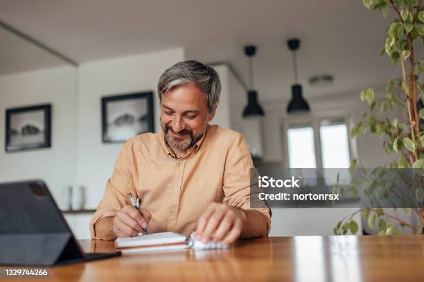 Adult Man Working On His Thesis At Home Stock Photo - Download Image Now - Mature Men, Writing - Activity, Handwriting