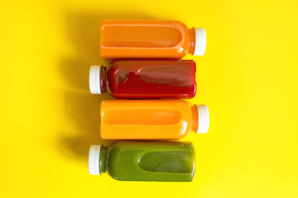 Fresh juices or smoothies of fruits and vegetables in bottles on a yellow background. The concept of a healthy diet, diet or detox stock photo
