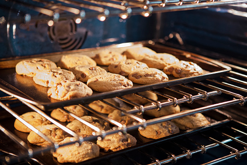 Freshly baked chocolate chip cookies baking in the oven.