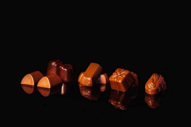 istock Close up of assorted chocolate sweets on a reflective surface 1329749498