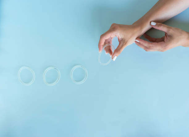 una mujer sostiene un anillo vaginal en sus manos con fines anticonceptivos - vagina contraceptive gynecologist doctor fotografías e imágenes de stock