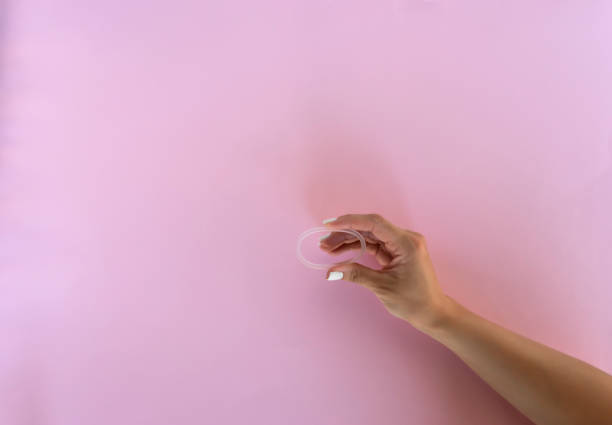 a woman holds a vaginal ring in her hands for contraception purposes - contraceção imagens e fotografias de stock