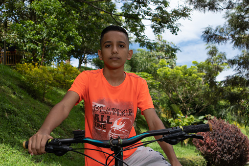 photo of a latin boy posing next to his mountain bike