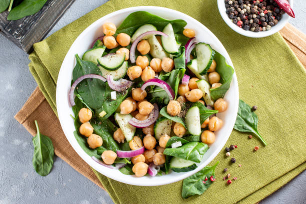 istock Spinach, cucumber, chickpeas, onions and lemon salad on a light table. Top view 1329758132