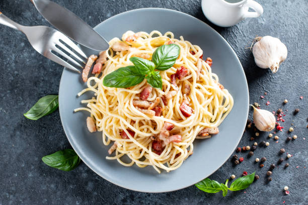 istock Carbonara pasta. Spaghetti with pancetta, egg, parmesan cheese and cream sauce. Top view. 1329758297