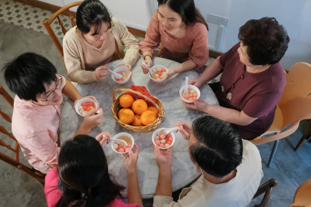 famille mangeant des boulettes de riz gluant (tangyuan) ensemble - 12 15 months photos et images de collection