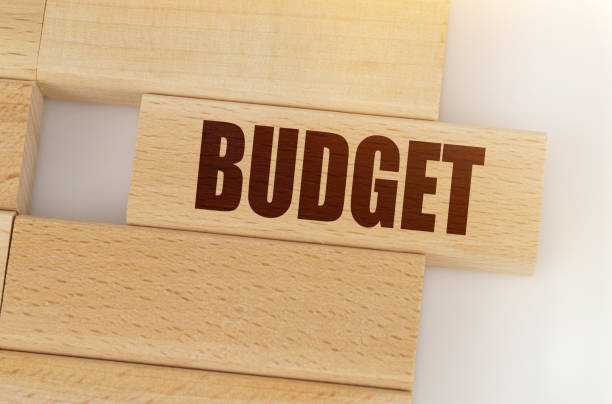 istock There is a wooden Jenga on the table, on one Jenga it is written - BUDGET 1329761047