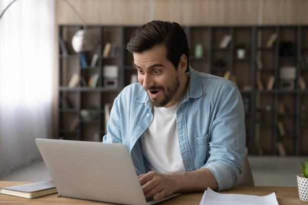 istock Surprised young male worker looking at laptop screen. 1329762957