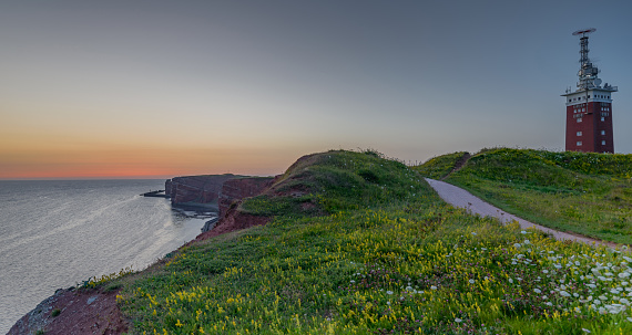 Panorama view of cliff coast Lummenfelsen and lighthouse of Heligoland in summer, island Helgoland, Schleswig-Holstein, Germany.