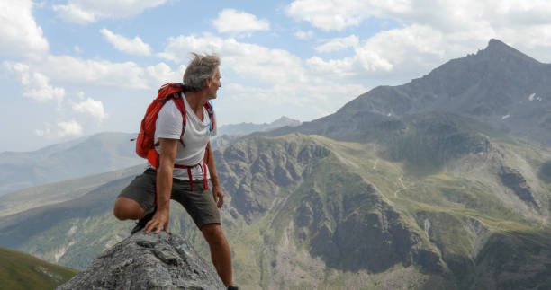 istock Mountaineer relaxes on rocky mountain ridge 1329764065