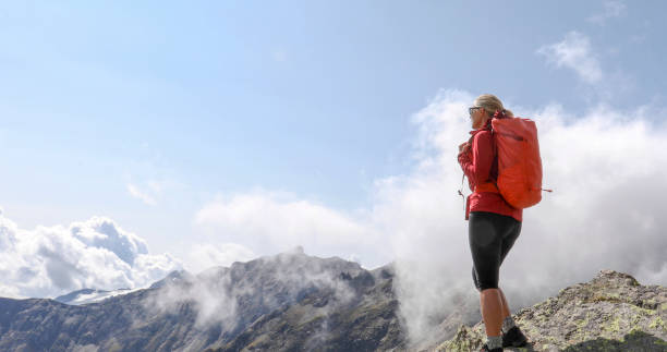 istock Female hiker relaxes on sunny mountain ridge 1329764076