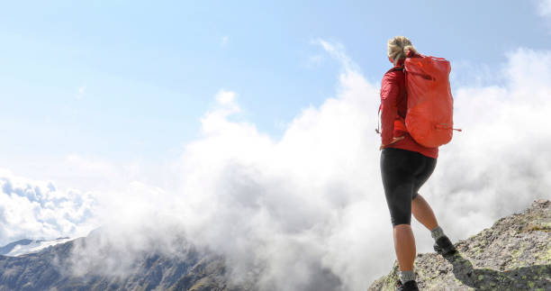 istock Female hiker relaxes on sunny mountain ridge 1329764077