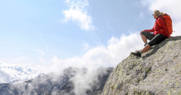 istock Female hiker relaxes on sunny mountain ridge 1329764093