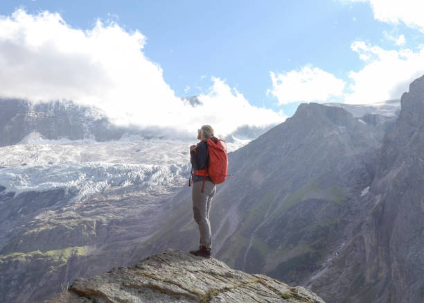 istock Female hiker relaxes on sunny mountain ridge 1329764113