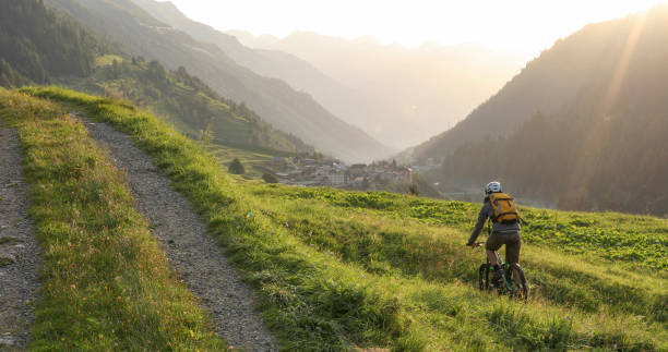 paseos en bicicleta de montaña en la zona de césped cerca de la carretera rural - 5601 fotografías e imágenes de stock