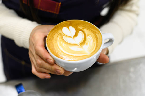 istock Hands of a young barista making coffee latte art. 1329768472