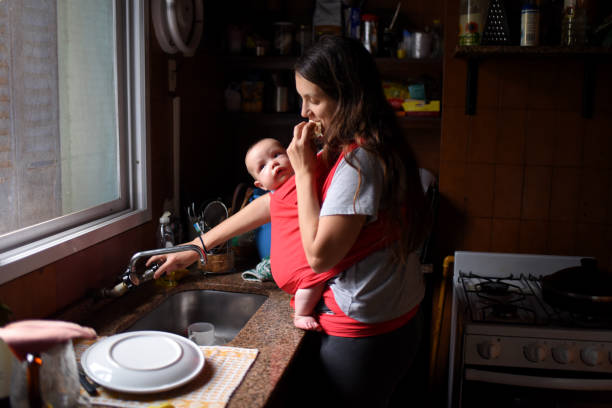 istock mother doing household chores with her baby 1329770486