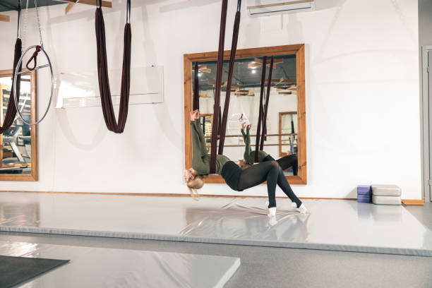 istock Proffesional beautiful slim caucasian woman is doing stretching exercises in modern studio 1329772272