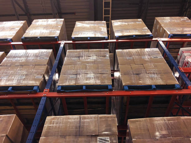 Cases of wine stacked on pallets in distribution center. Many cases of wine stacked on pallets in distribution center. wine shipping stock pictures, royalty-free photos & images