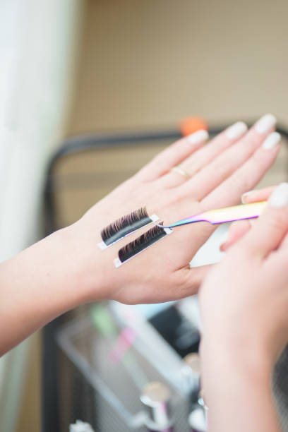 istock Aesthetic medicine, eyelash extension process: girl's hand with tools 1329775706