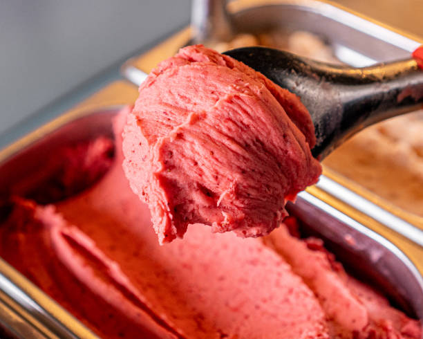 Delicious strawberry gelato on a base. Delicious strawberry gelato on a base and held by a spoon. gelato stock pictures, royalty-free photos & images