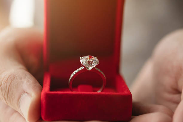 istock hands holding diamond ring in jewelry box 1329779725