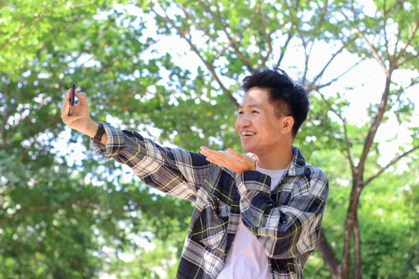 istock Asian young men using a phone video call at the park 1329785968