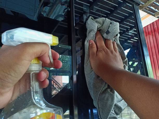 istock a man's hand is wiping the cupboard glass 1329791140