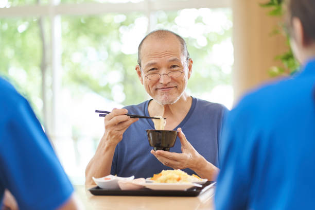 istock Elderly people having fun eating at a long-term care facility 1329798889