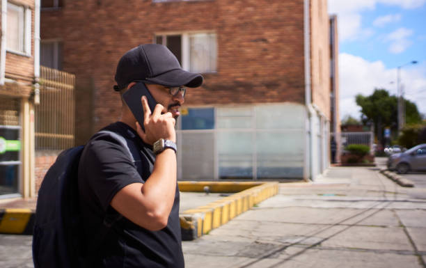istock serious young man talking on cell phone in the street 1329800414