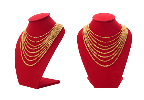 Gold necklaces on red necklace display stand. isolated on white background.