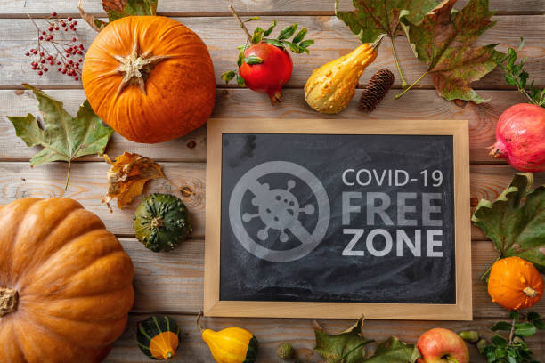 Covid free zone sign. COVID-19 free zone text on thanksgiving table Covid free zone sign. COVID 19 FREE ZONE text label on thanksgiving background. Holiday table safe, disinfected areas, vaccinated only concept thanksgiving holiday covid stock pictures, royalty-free photos & images