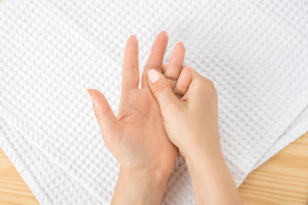 caucasian woman with hand on her unhealthy finger and palm. Self massage, office syndrome and musclar pain. Closeup hand of person massage her hand from pain in healthy concept accupressure caucasian woman with hand on her unhealthy finger and palm. Self massage, office syndrome and musclar pain. one female hand massages the other hand lying on a white towel with the open palm up hand massage photos stock pictures, royalty-free photos & images