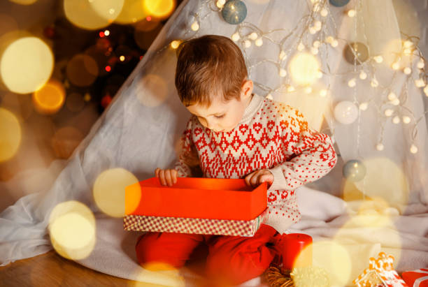 istock Surprised child opening a Christmas present. Little kid having fun 1329805981