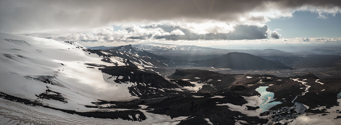 Langjökull Glacier Mountain Range, Þórisjökull and Highlands Aerial Drone Point of View XXL Panorama under sunny dramatic summer sky. View along the Langjökull Glacier, second largest ice cap in Iceland, and surrounding icelandic gravel highlands cold valley with crossing small rivers. Stiched Panorama. Langjökull Glacier, Western Icelandic Interior Highlands, Iceland, Northern Europe.
